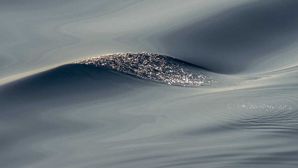 a large wave in the water with a sky background