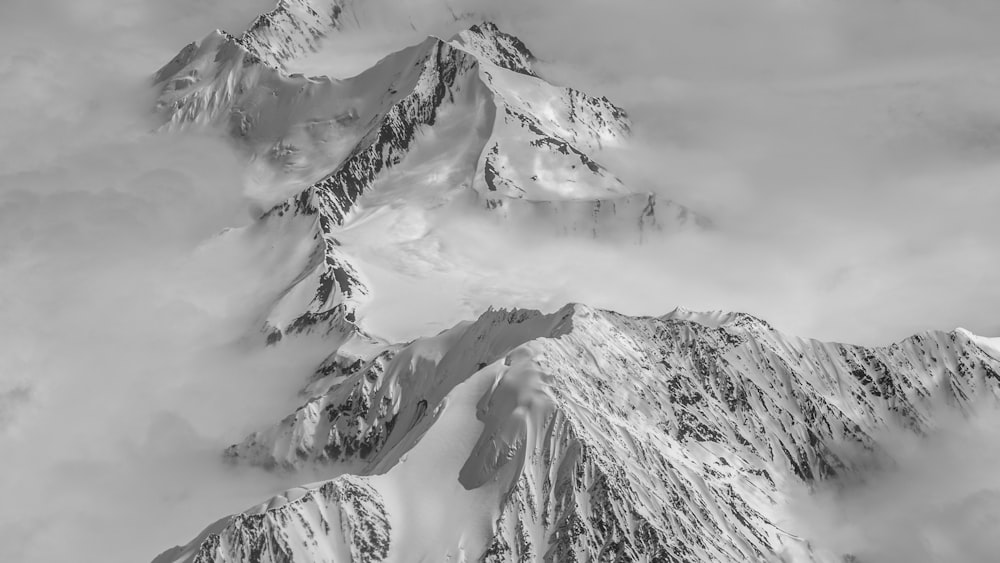 a black and white photo of snow covered mountains