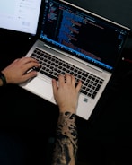 a man is typing on a laptop computer