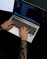 a man is typing on a laptop computer