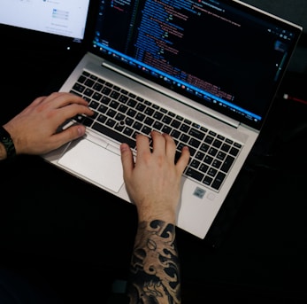 a man is typing on a laptop computer