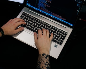 a man is typing on a laptop computer