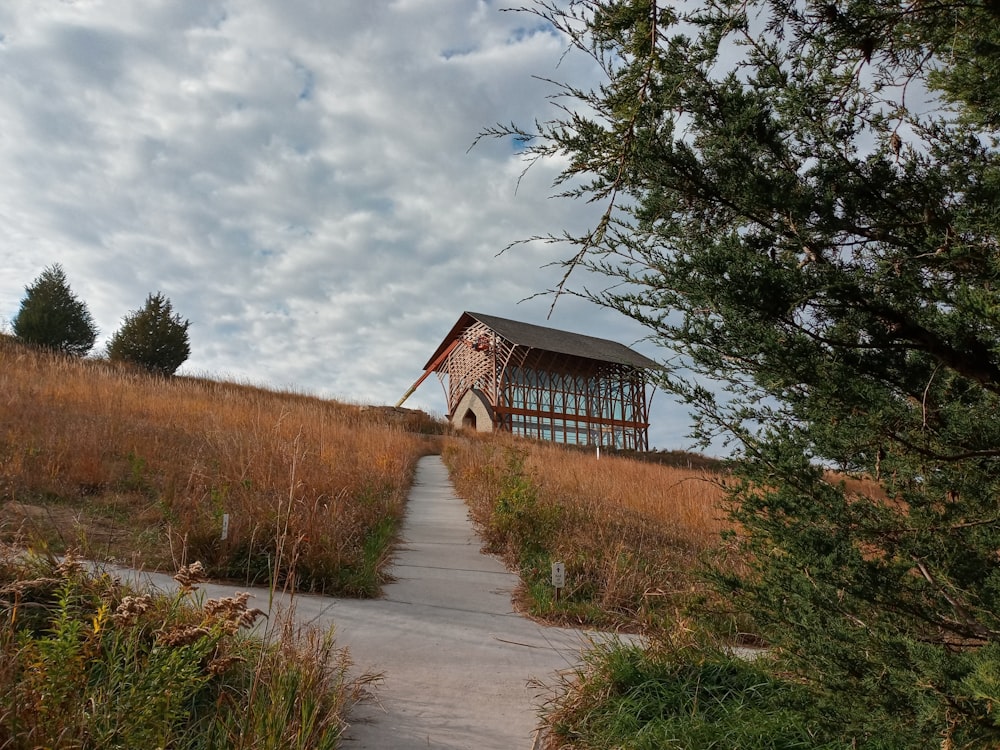 a wooden structure sitting on top of a grass covered hillside