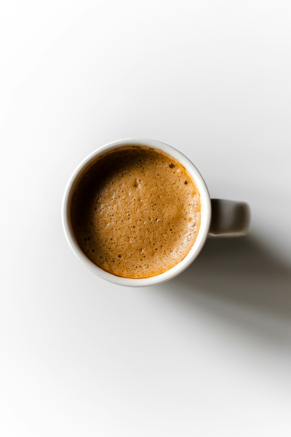 a cup of coffee sitting on top of a white table