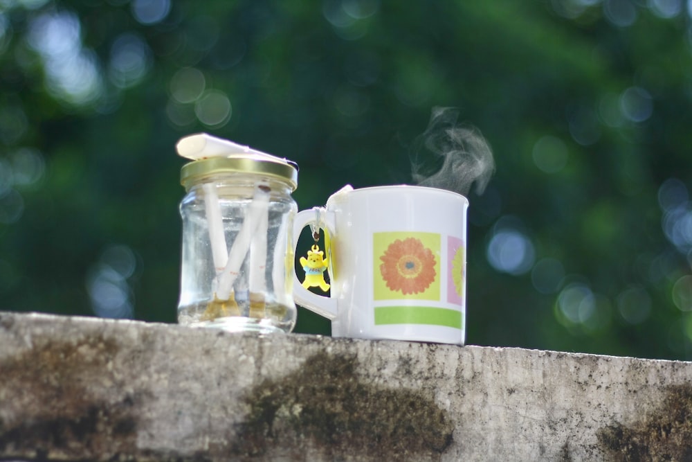 two coffee mugs sitting next to each other on a ledge