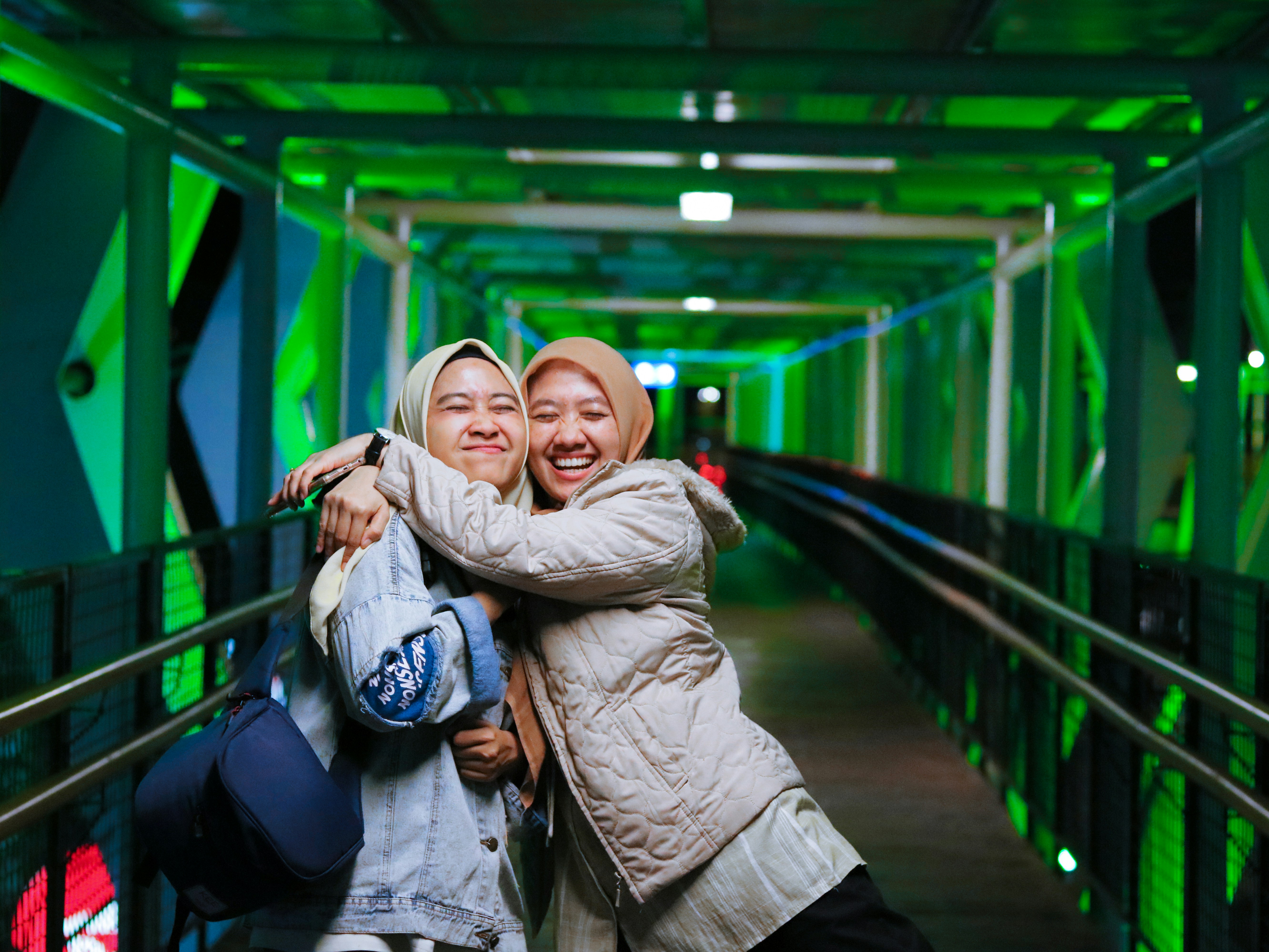 two women hugging each other on a bridge