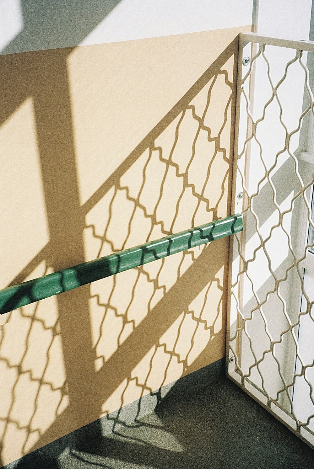 the shadow of a fence on a wall