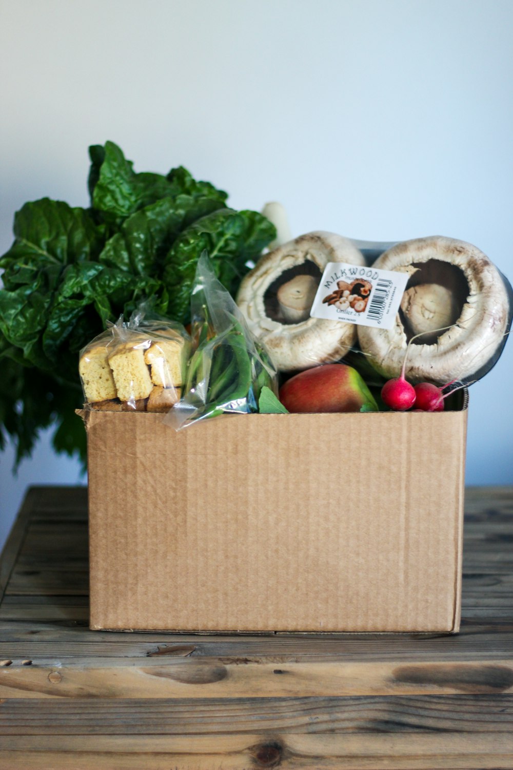 a box filled with food sitting on top of a wooden table