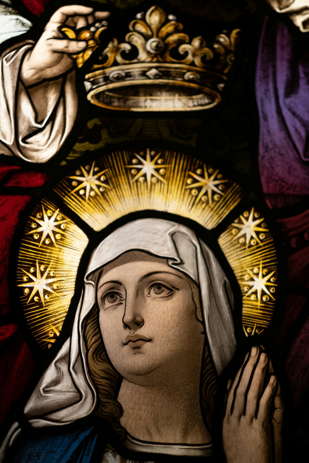 a stained glass window with a woman holding a crown