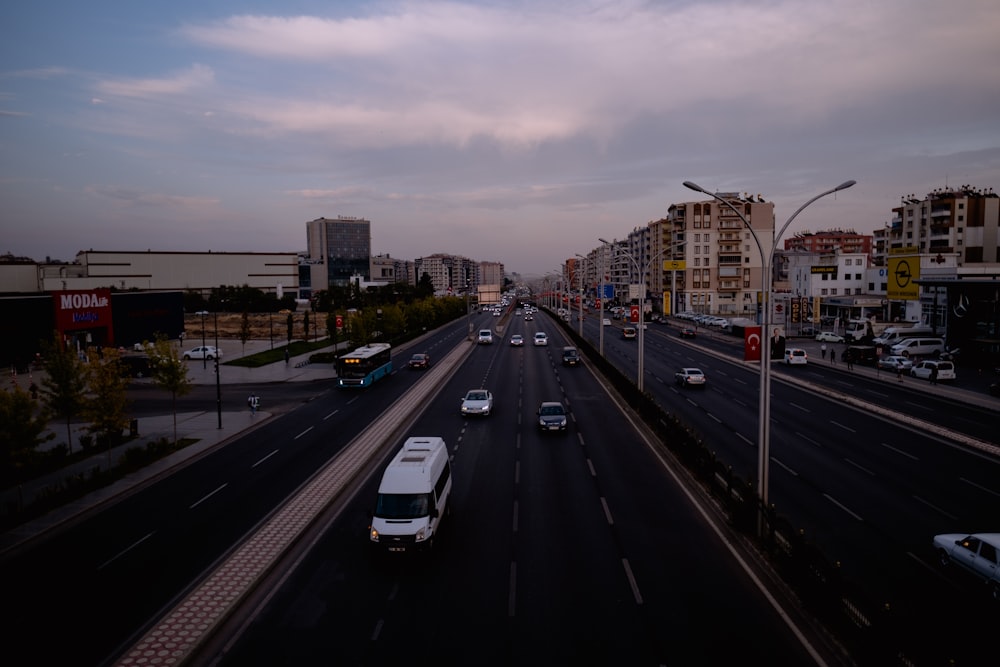 a city street filled with lots of traffic under a cloudy sky