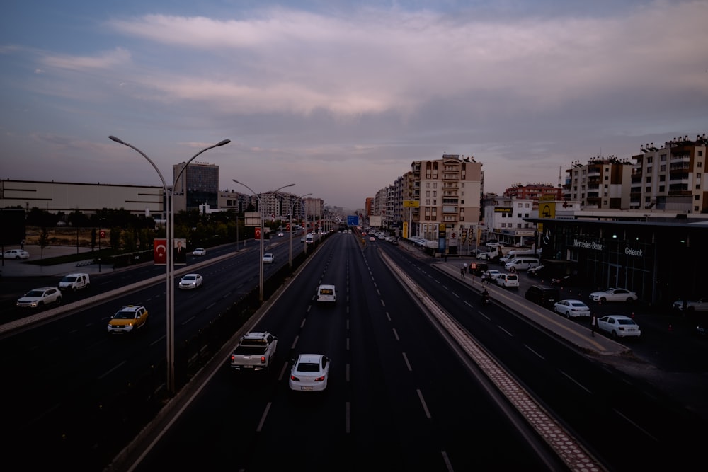 a city street filled with lots of traffic under a cloudy sky