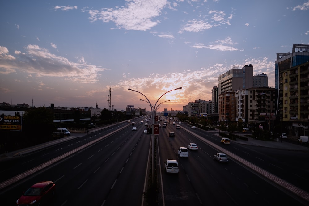 the sun is setting over a busy city street