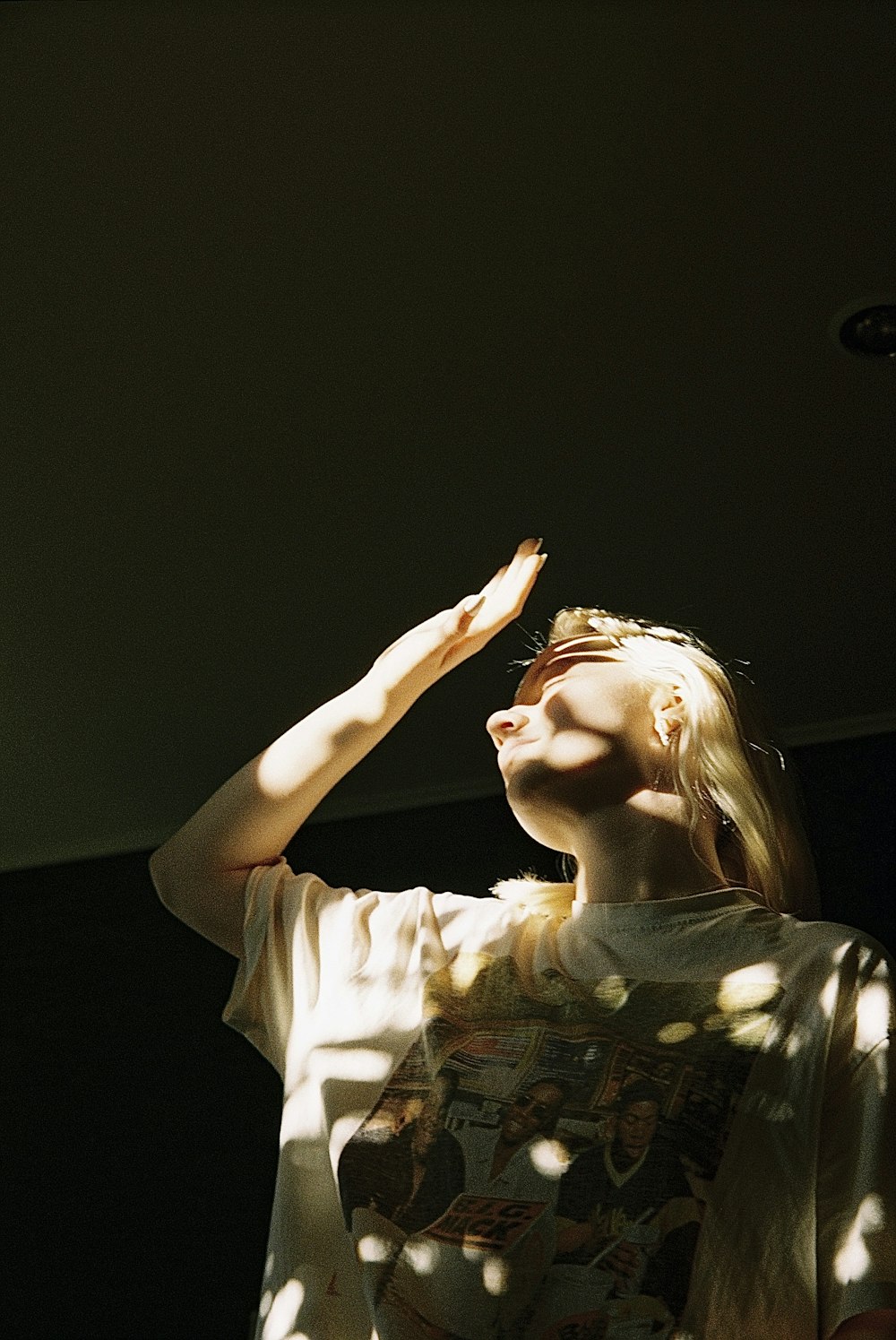 a woman standing under a tree with her hands in the air