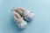 Close-up of soft leather baby slippers in pastel colors on a wooden surface.
