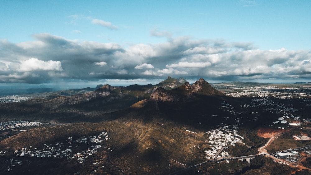 an aerial view of a mountain range with clouds in the sky