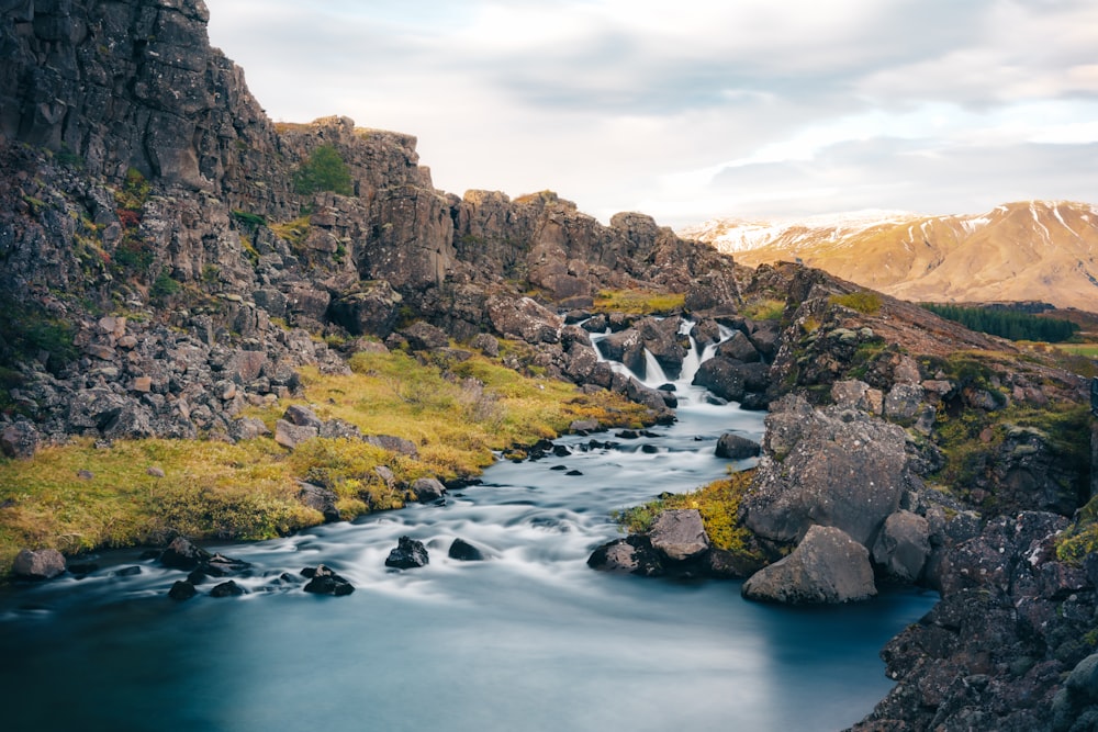 a river running through a lush green hillside