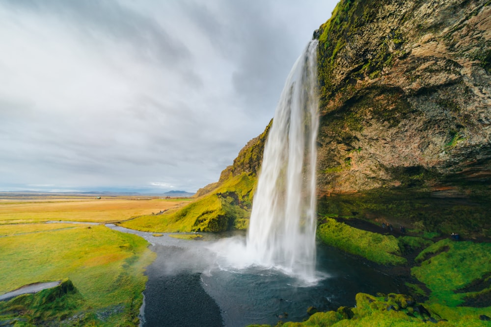 a waterfall with a body of water in front of it