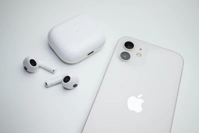 A sleek modern smartphone and wireless earbuds displayed on a clean white surface