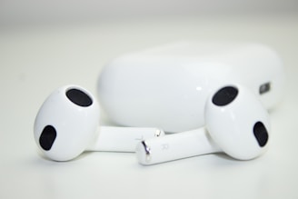 Wireless earbuds charging in their compact case on a smooth surface.