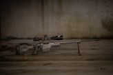 a rifle laying on the ground with a scope
