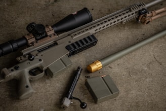 a rifle, a rifle, and a gun laying on the ground