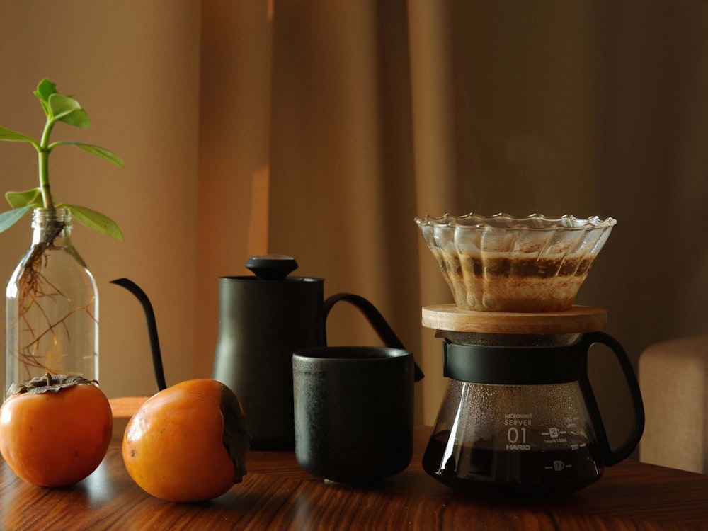 a wooden table topped with a coffee pot filled with liquid