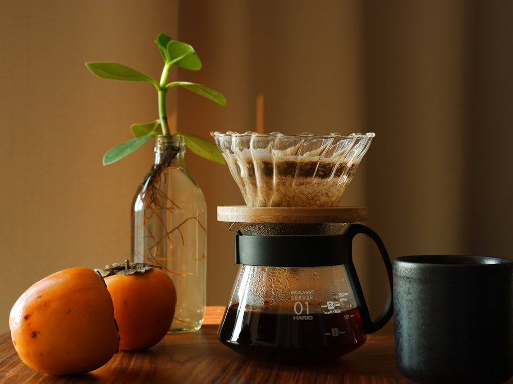 a wooden table topped with a coffee pot filled with liquid