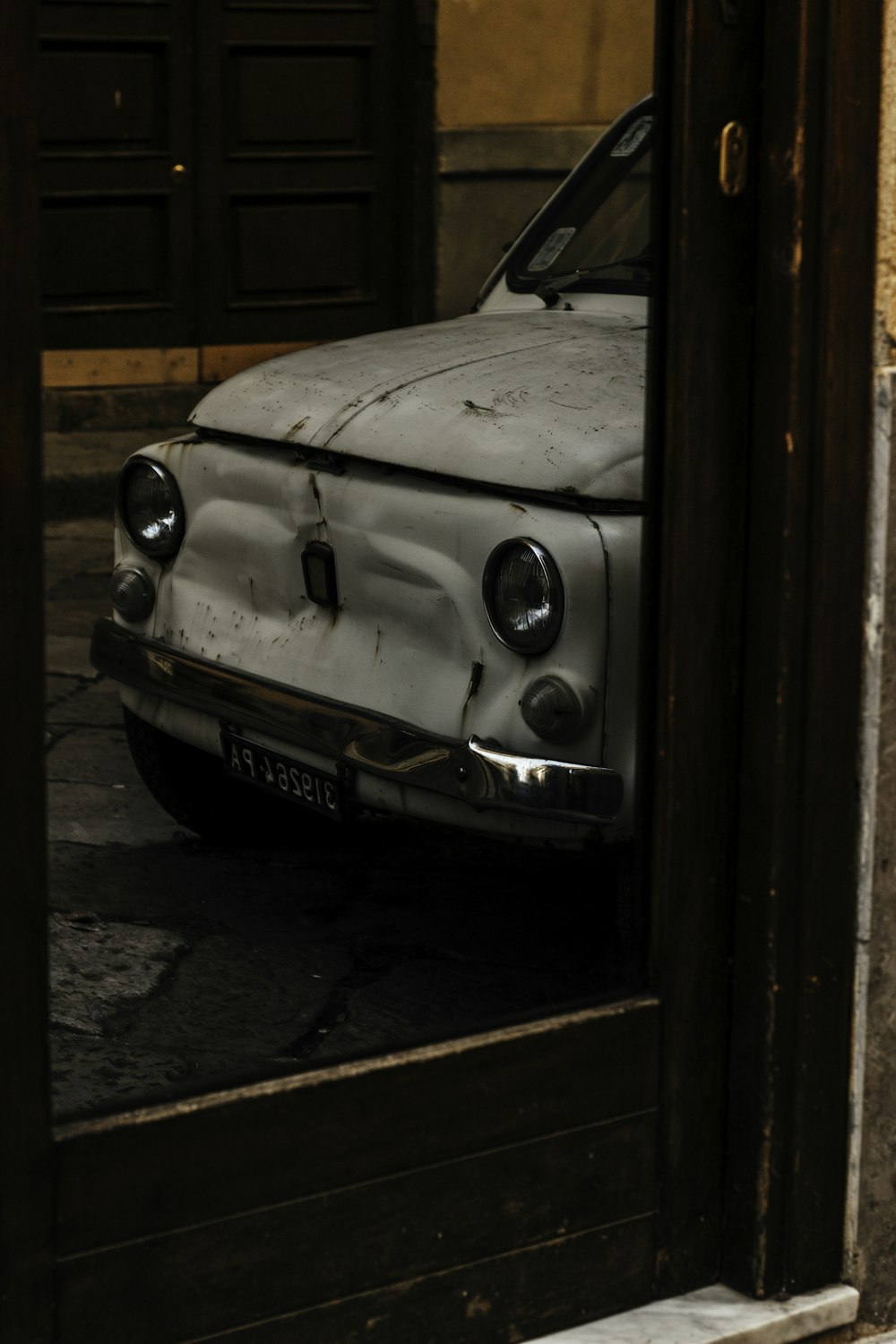 an old car is parked in a doorway