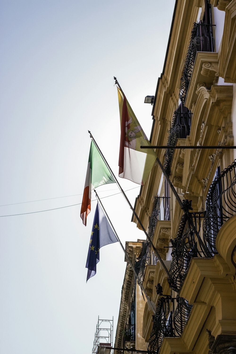 a group of flags hanging from the side of a building