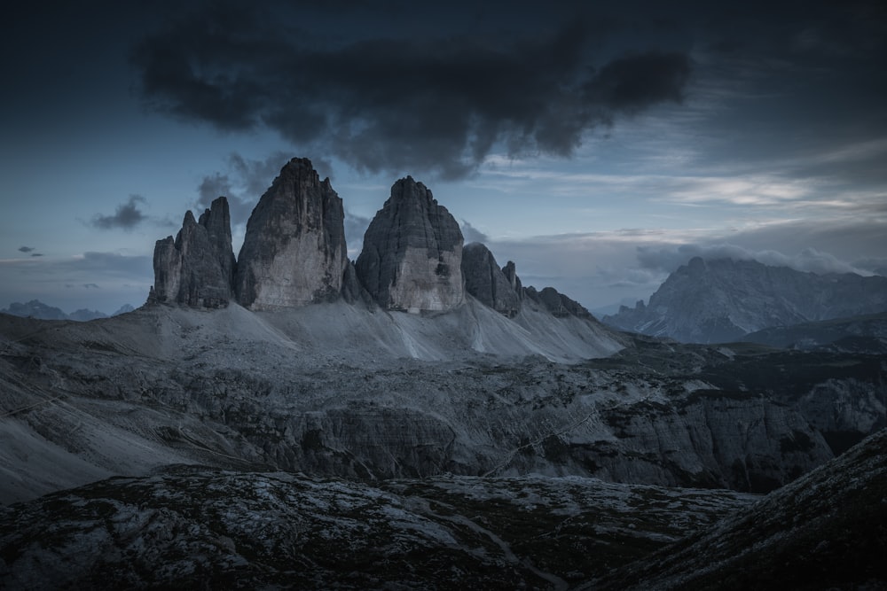 a group of mountains with a dark sky in the background