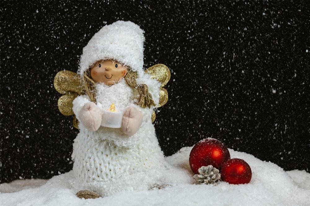 a snow angel holding a lit candle in the snow