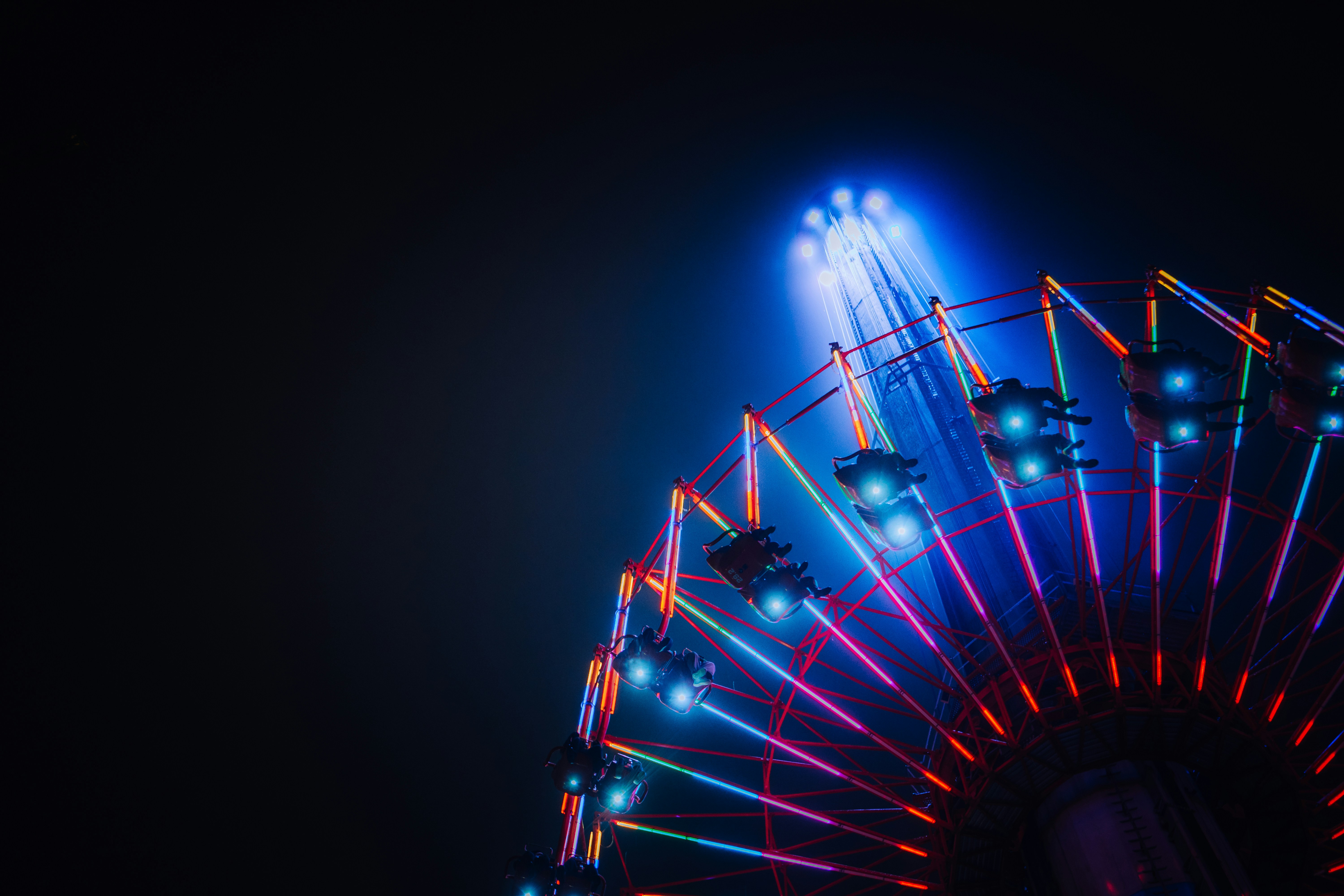uma roda gigante iluminada à noite com luzes brilhantes