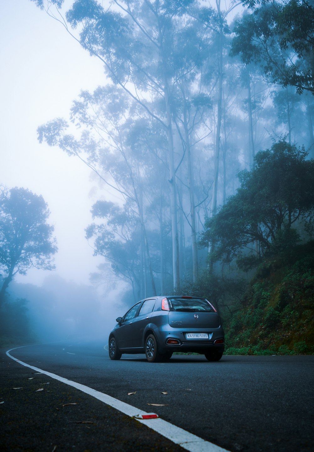 a car driving down a road in the fog