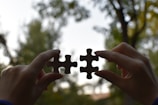 a person holding two pieces of a puzzle
