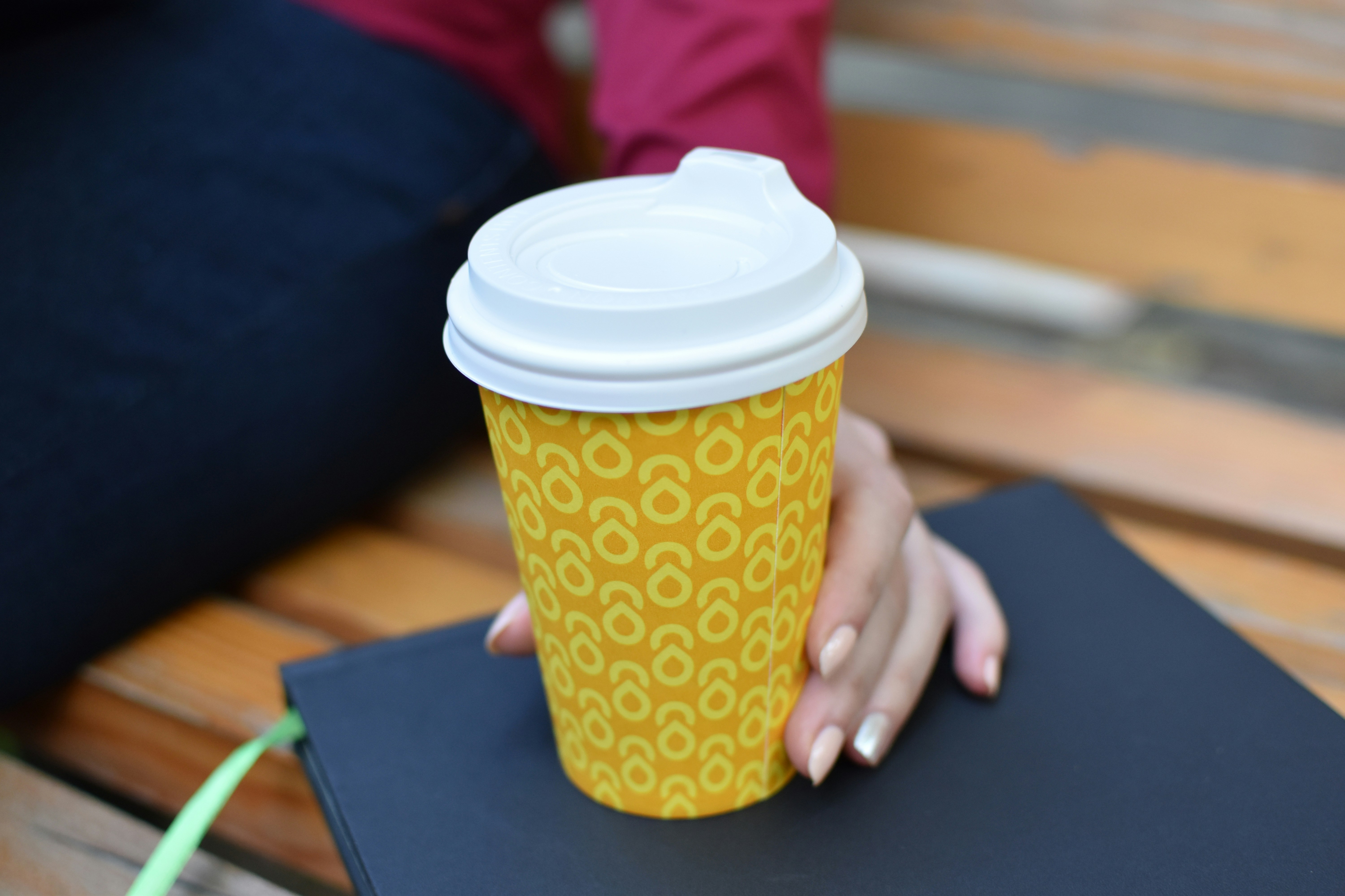 a woman holding a cup of coffee on top of a book