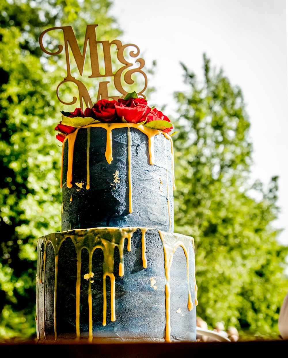 a three tiered cake with dripping yellow icing