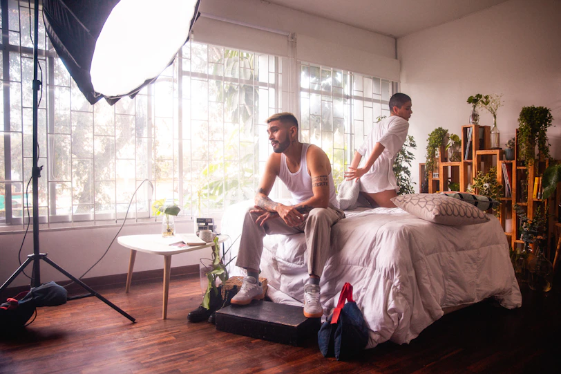 a man and a woman sitting on a bed