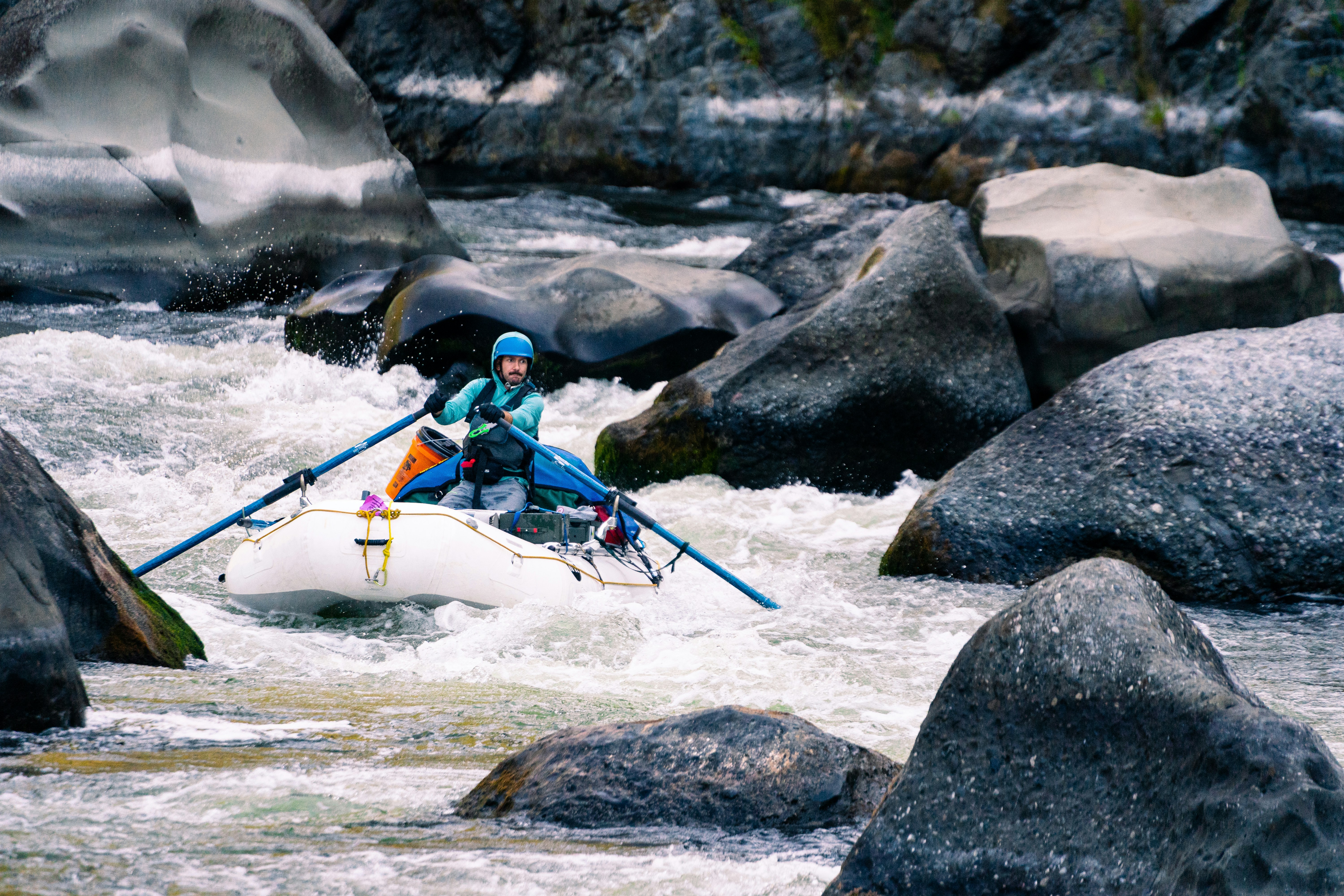 a man in a kayak on a river surrounded by rocks, Rafting through the notorious rapid, Blossom Bar, on the Wild & Scenic Section of the Rogue River. 