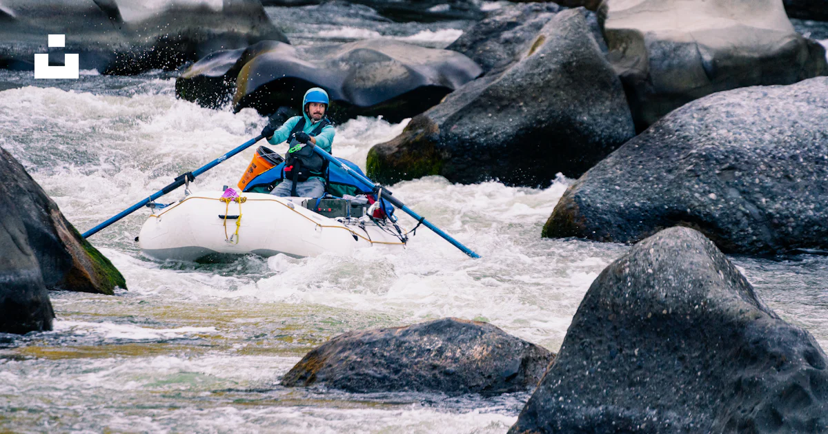 A man in a kayak on a river surrounded by rocks photo – Free Rogue ...