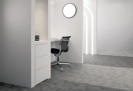 A tidy, minimalist office space with black furniture and subtle pink accents, freshly cleaned.