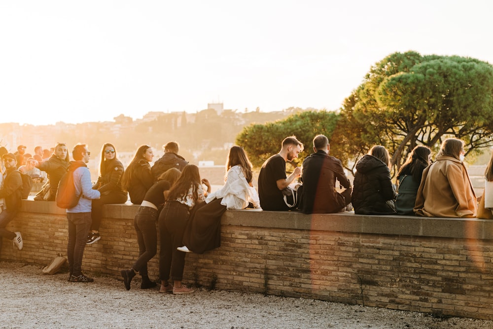 a group of people standing next to a brick wall