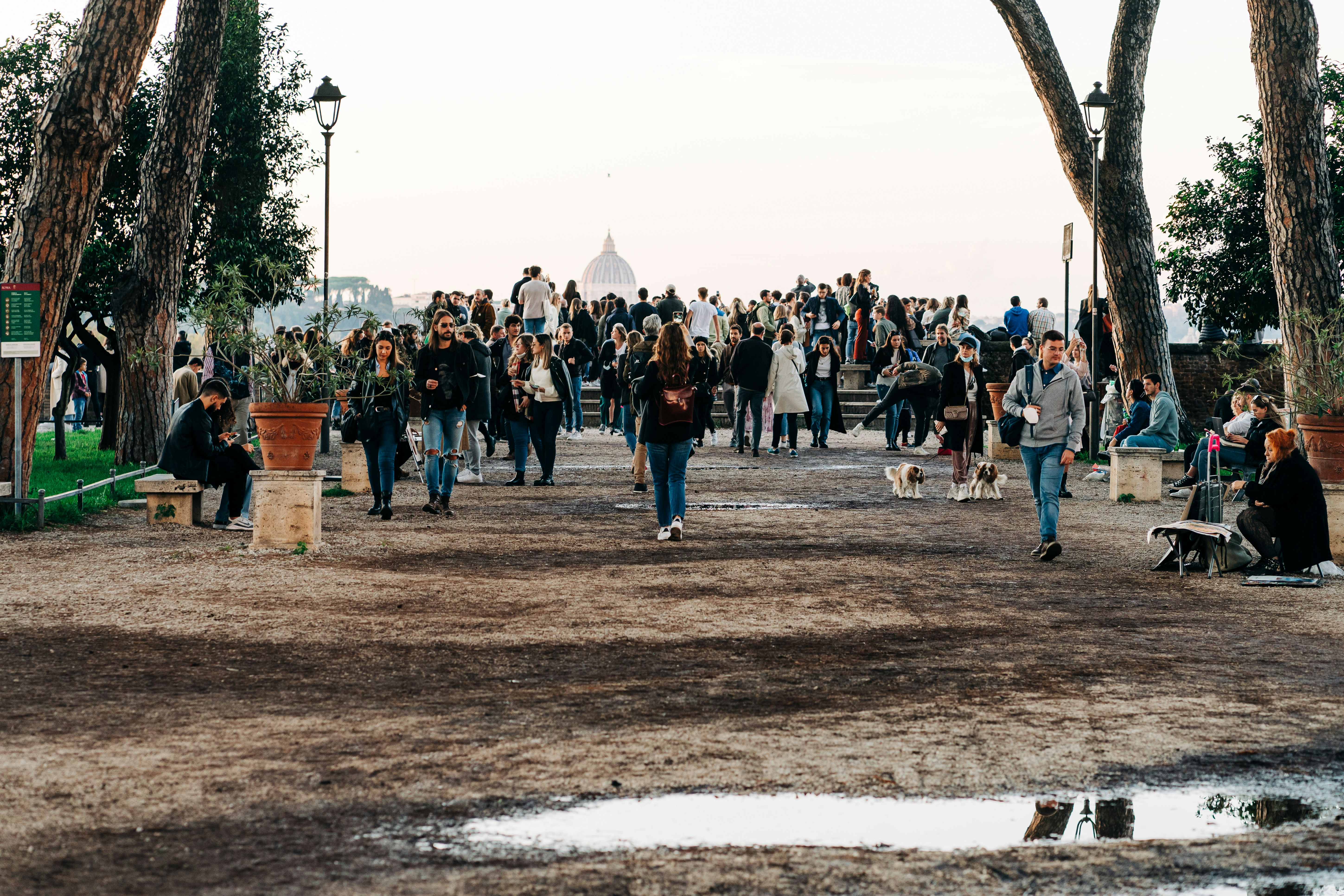Tourists and locals mingle at sunset in Giardino degli Aranci in Rome, Italy