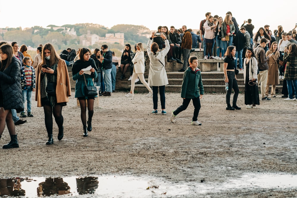 a group of people walking across a dirt field