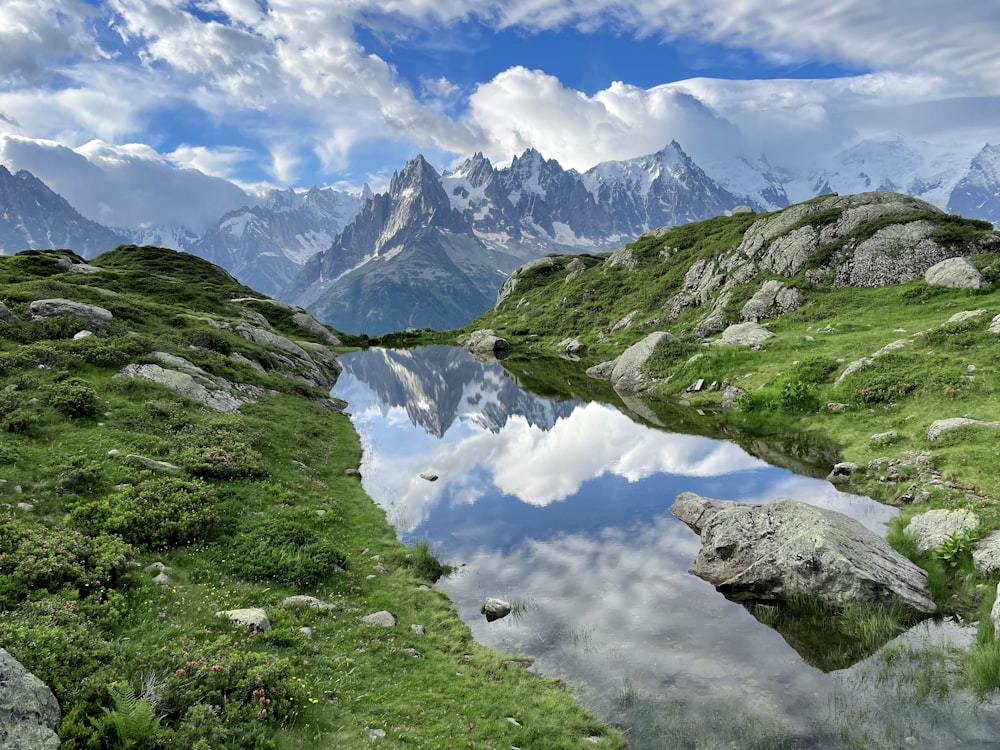 a mountain lake surrounded by grass and rocks