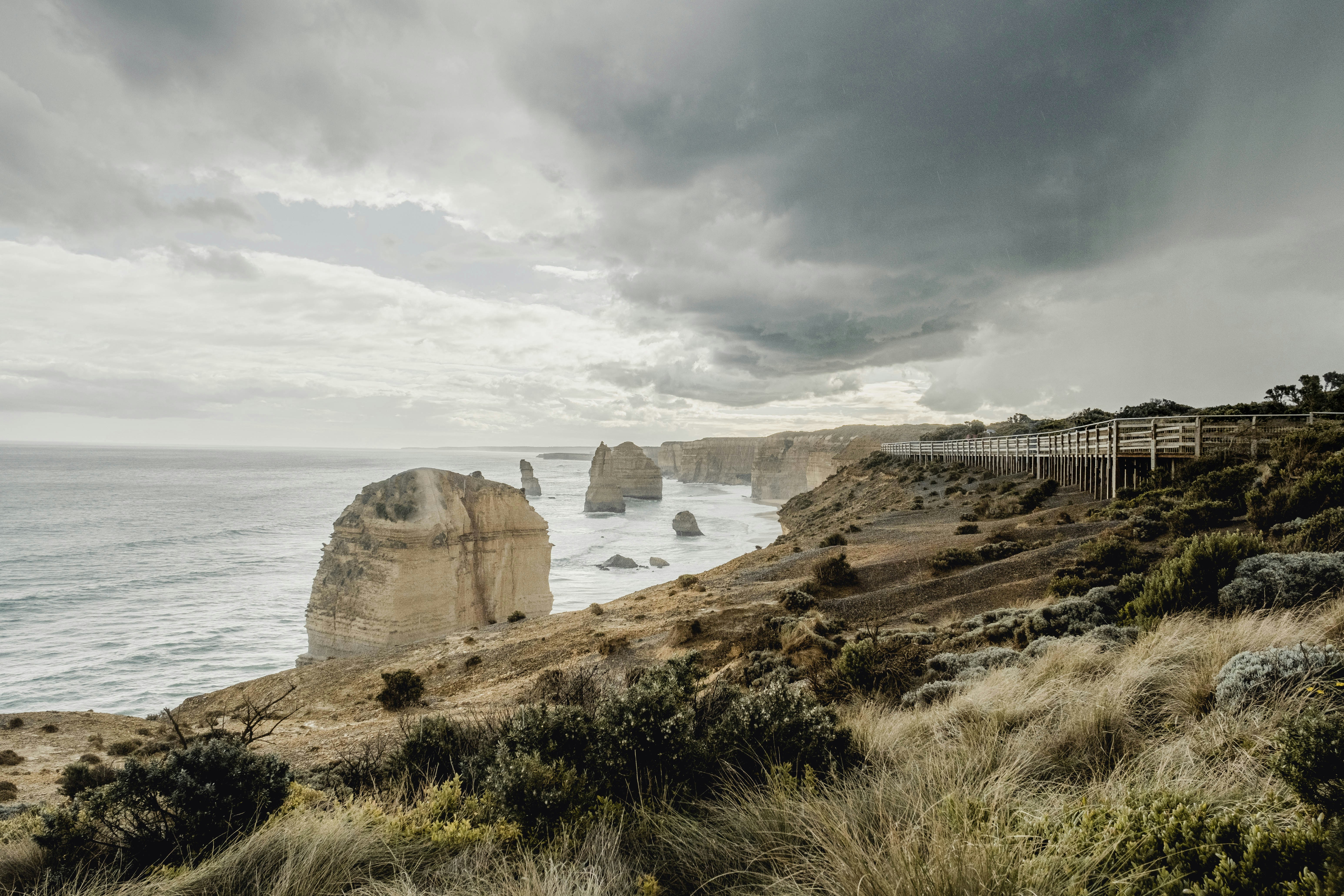 a scenic view of the ocean and cliffs under a cloudy sky