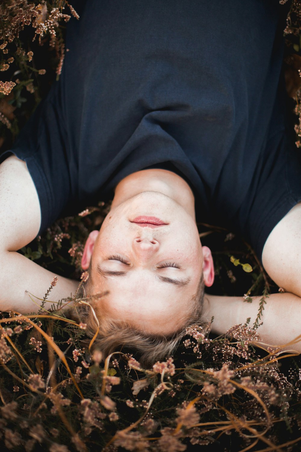 a man laying in the grass with his eyes closed