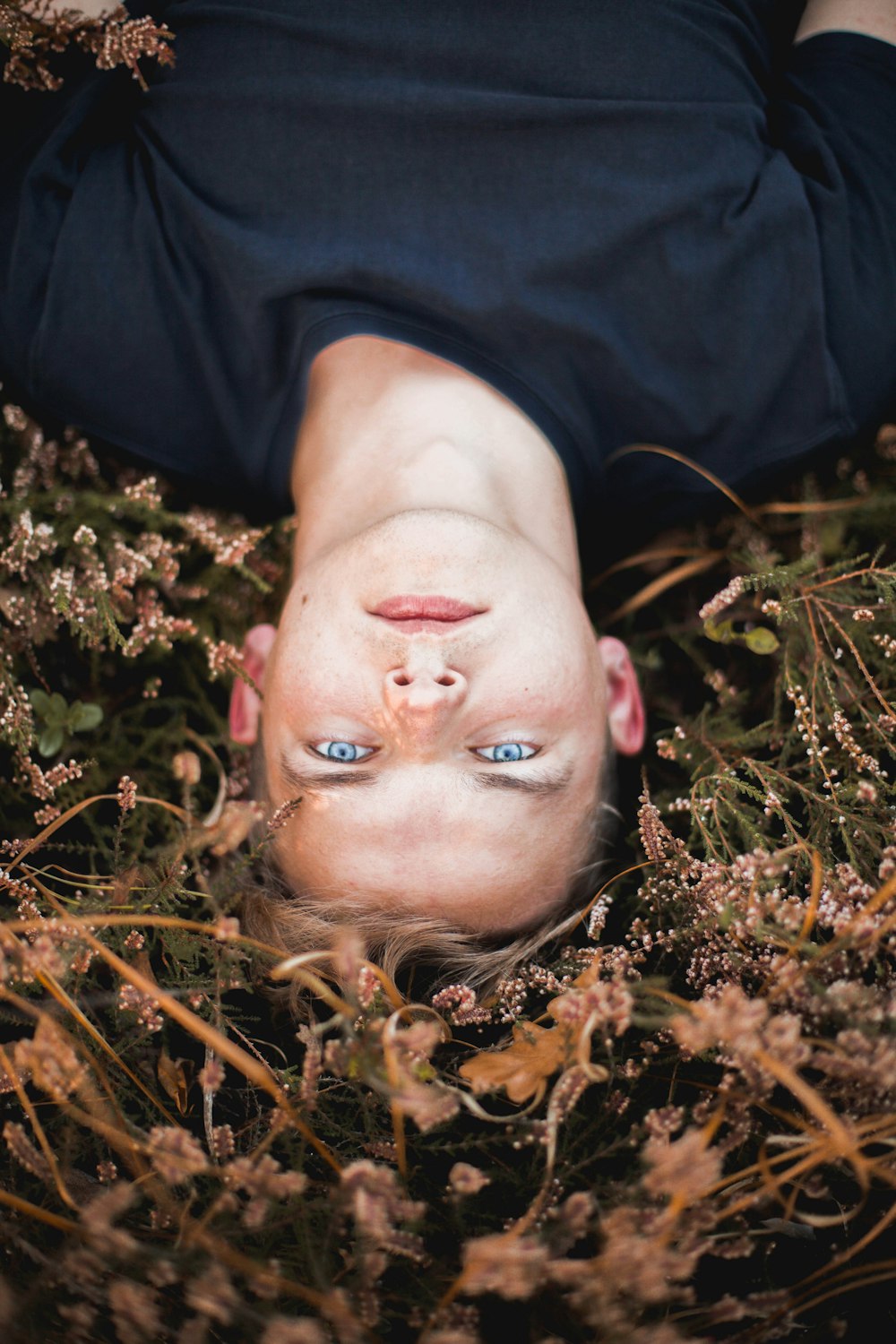 a woman laying in a field of flowers