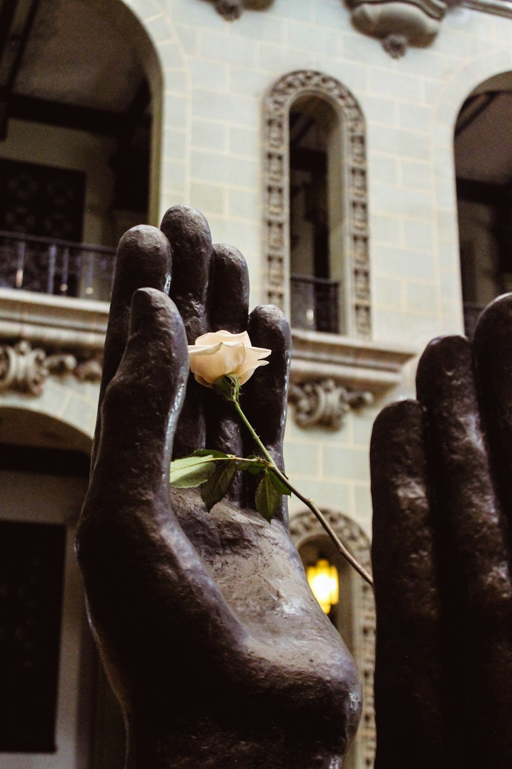 une statue d’une main tenant une rose