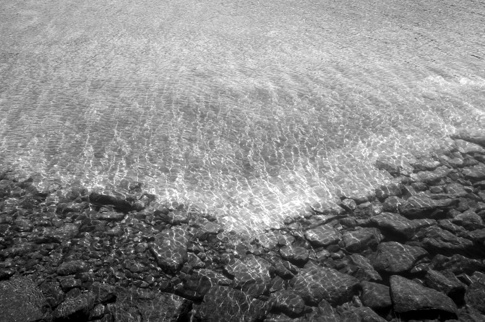 a black and white photo of rocks and water