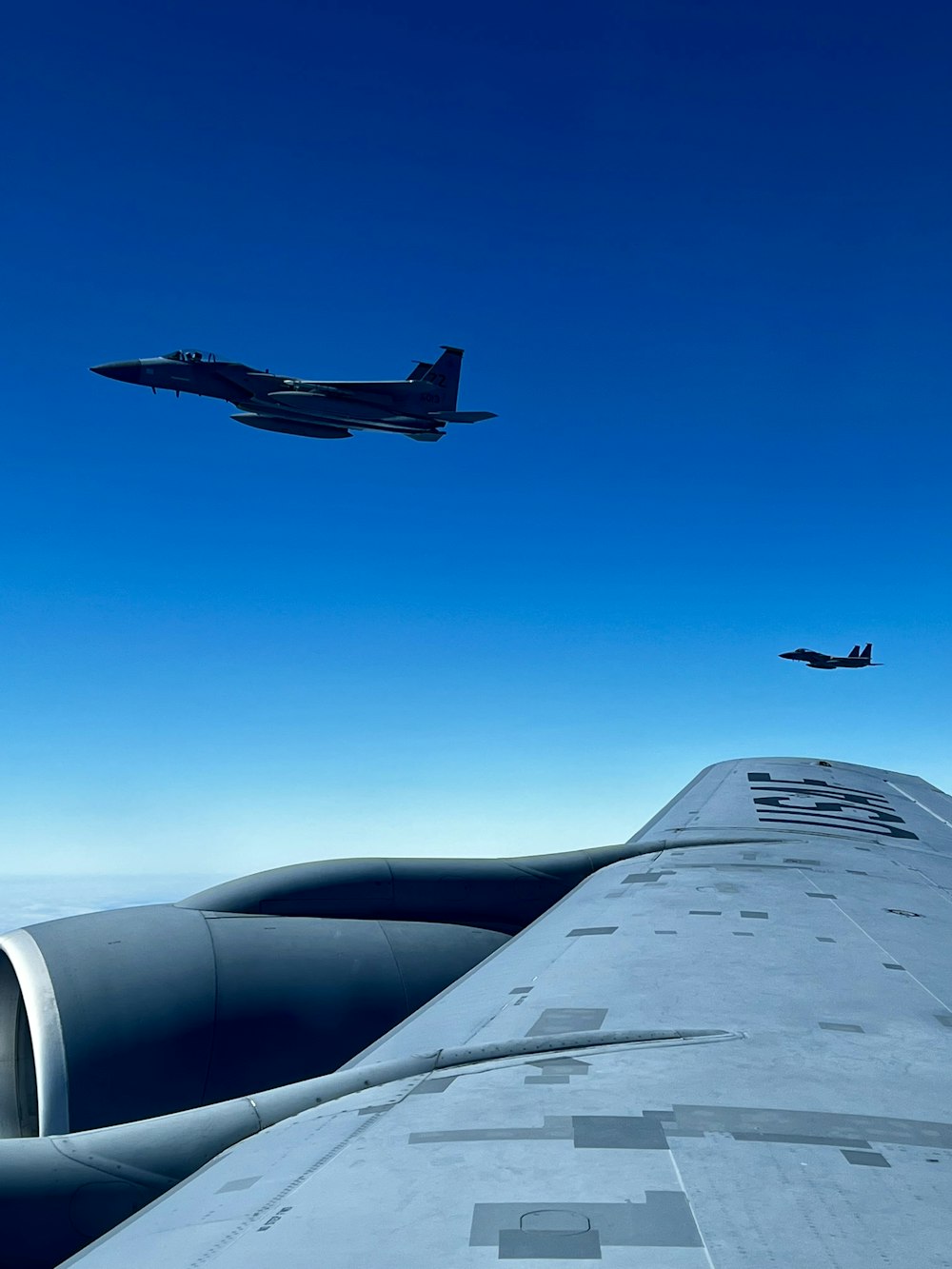 two planes flying in the sky near each other